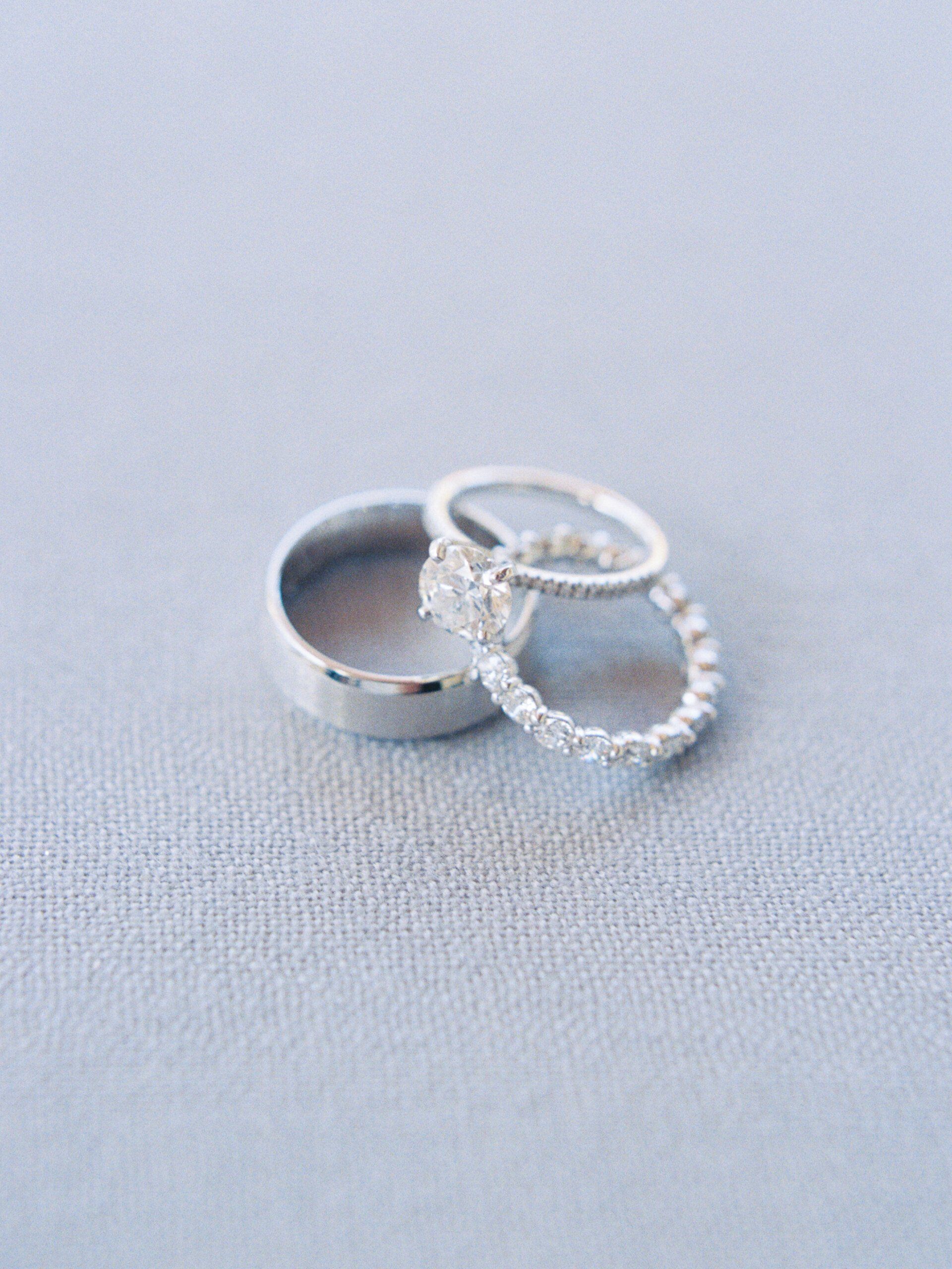 Three silver rings on a light gray fabric background