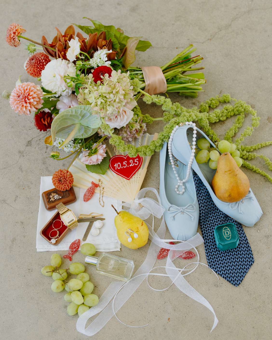Bouquet with pastel flowers, pearl shoes, and jewelry arranged on a light background.