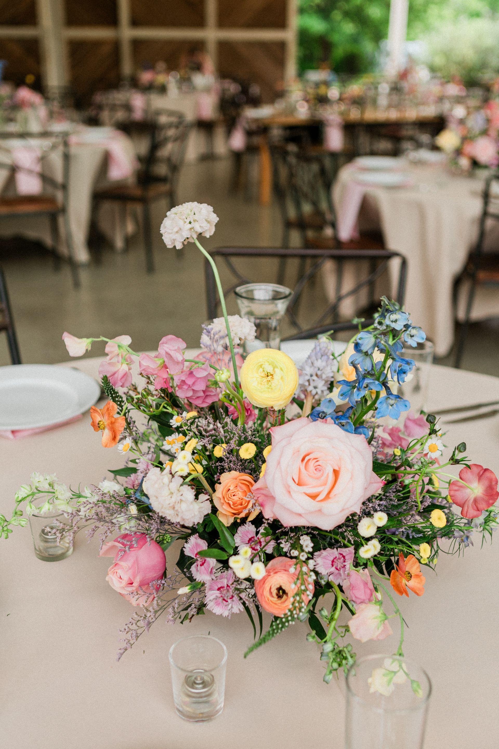 Pastel floral centerpiece on a table in a softly lit banquet room