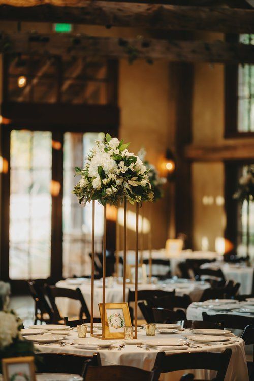 Elegant banquet table with white floral centerpiece and candles in a warmly lit hall