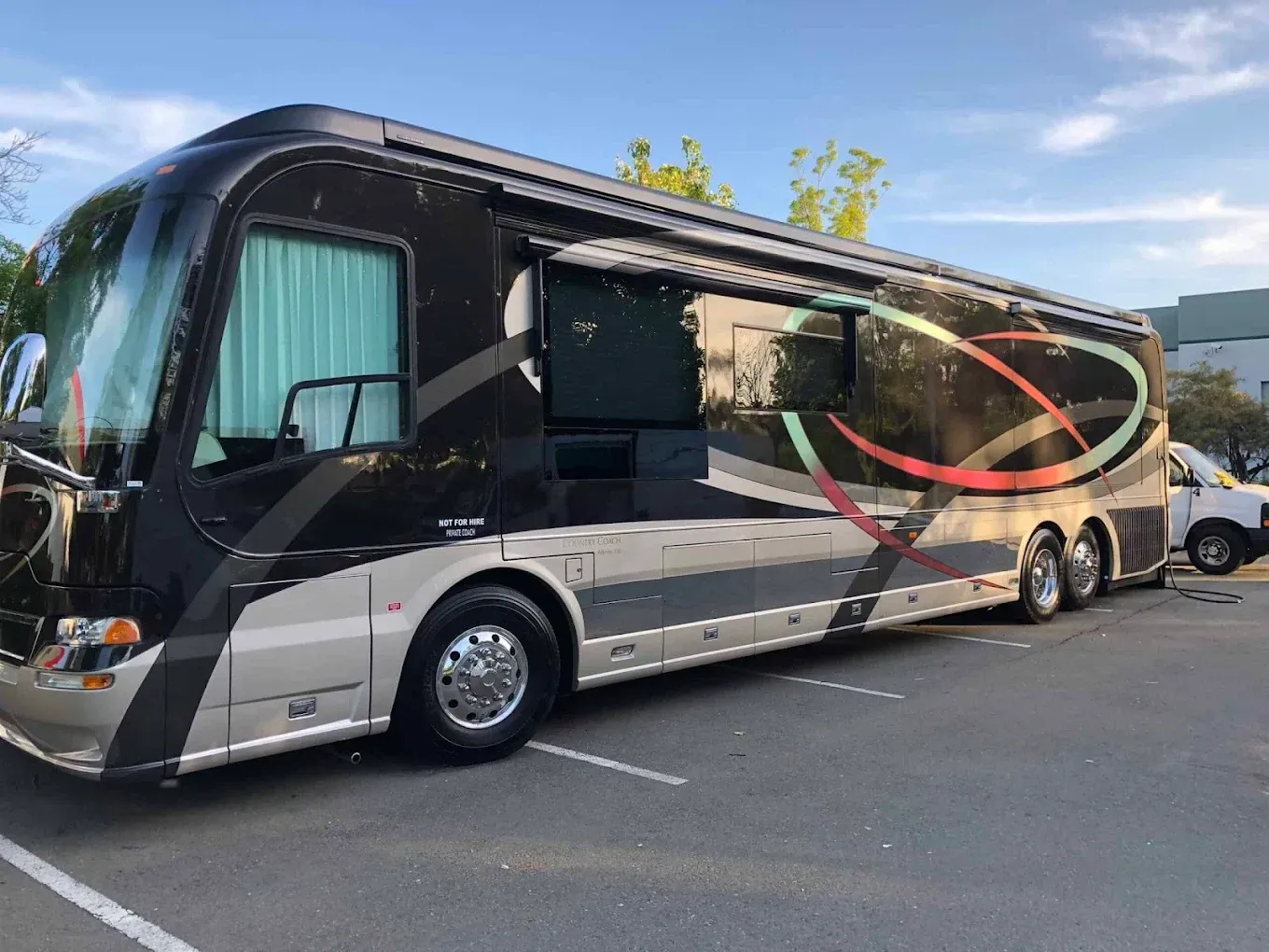 Black luxury motor coach parked outdoors, with a red oval highlighting the side window area.