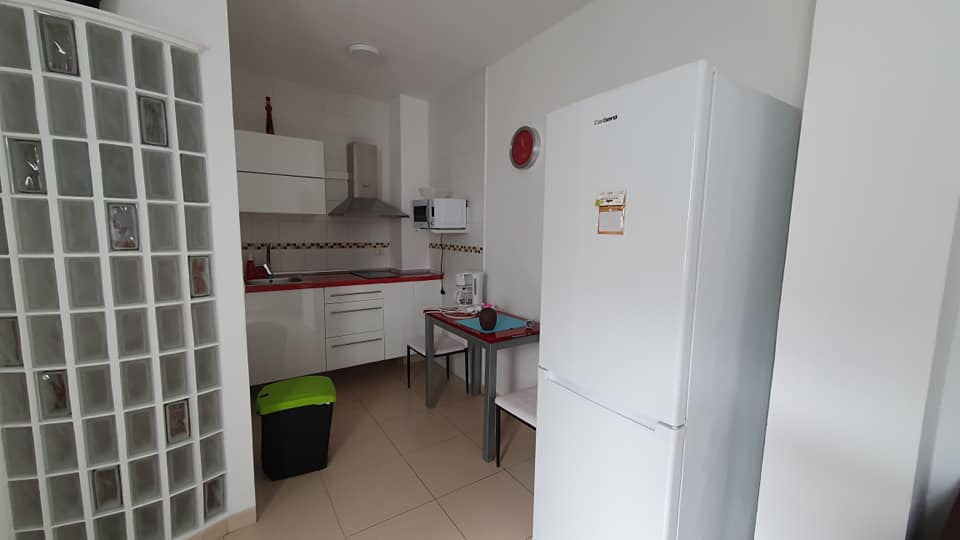Eine Küche mit Kühlschrank und Tisch