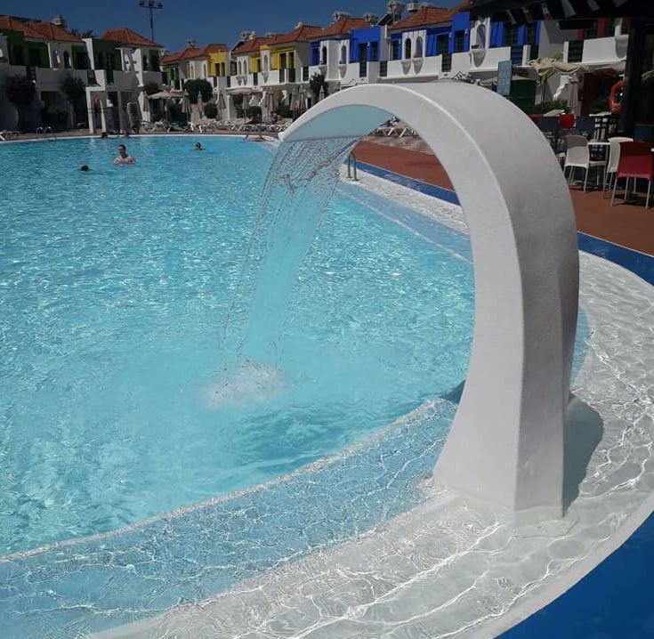 Ein großes Schwimmbecken mit einem Wasserfall in der Mitte
