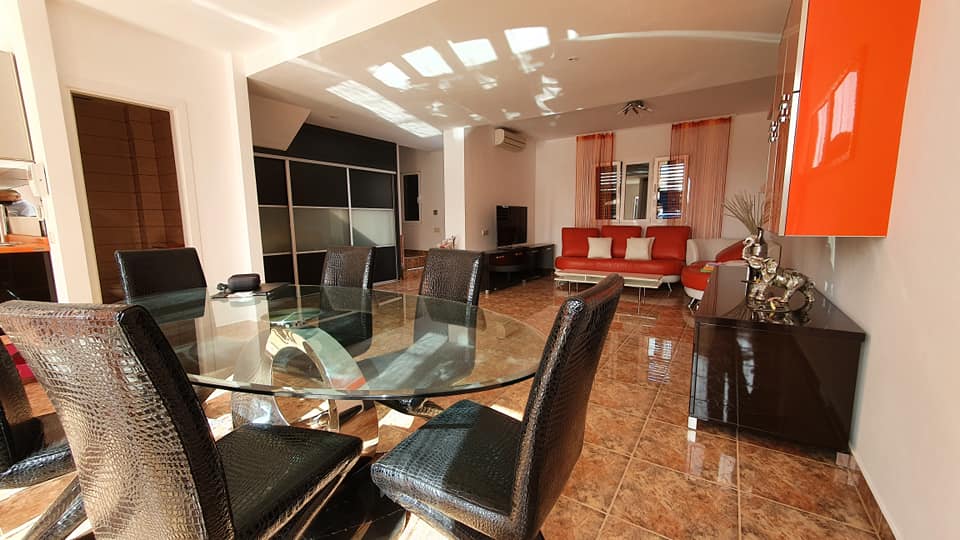 Ein Wohnzimmer mit Glastisch und Stühlen