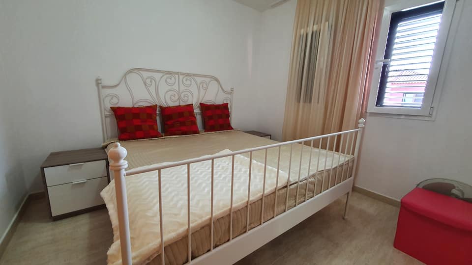 Ein Schlafzimmer mit Bett, Nachttisch und Fenster.