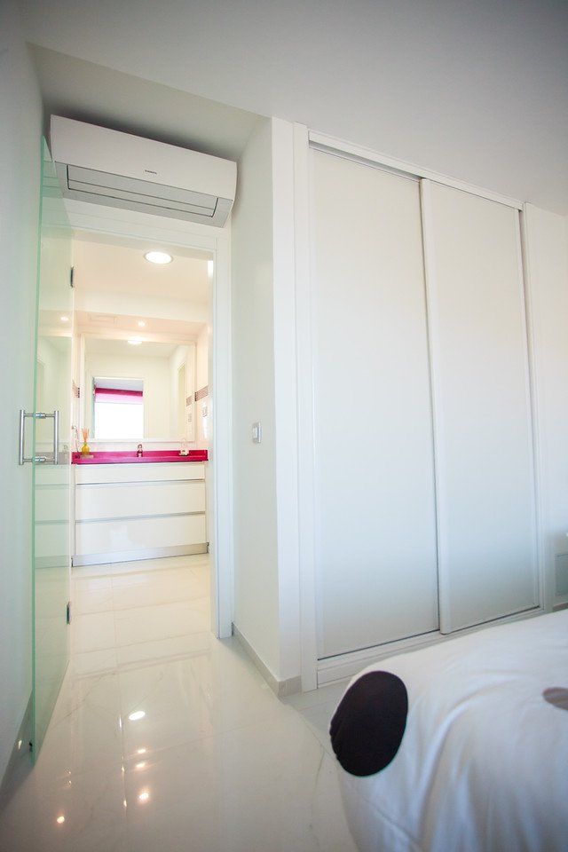 Ein Schlafzimmer mit Bett und einem Badezimmer im Hintergrund