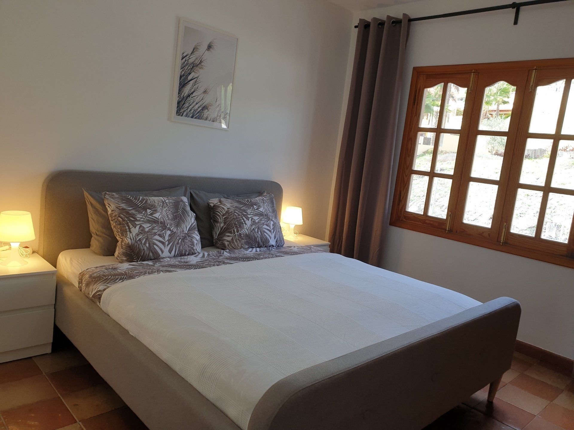 Ein Schlafzimmer mit großem Bett und zwei Fenstern