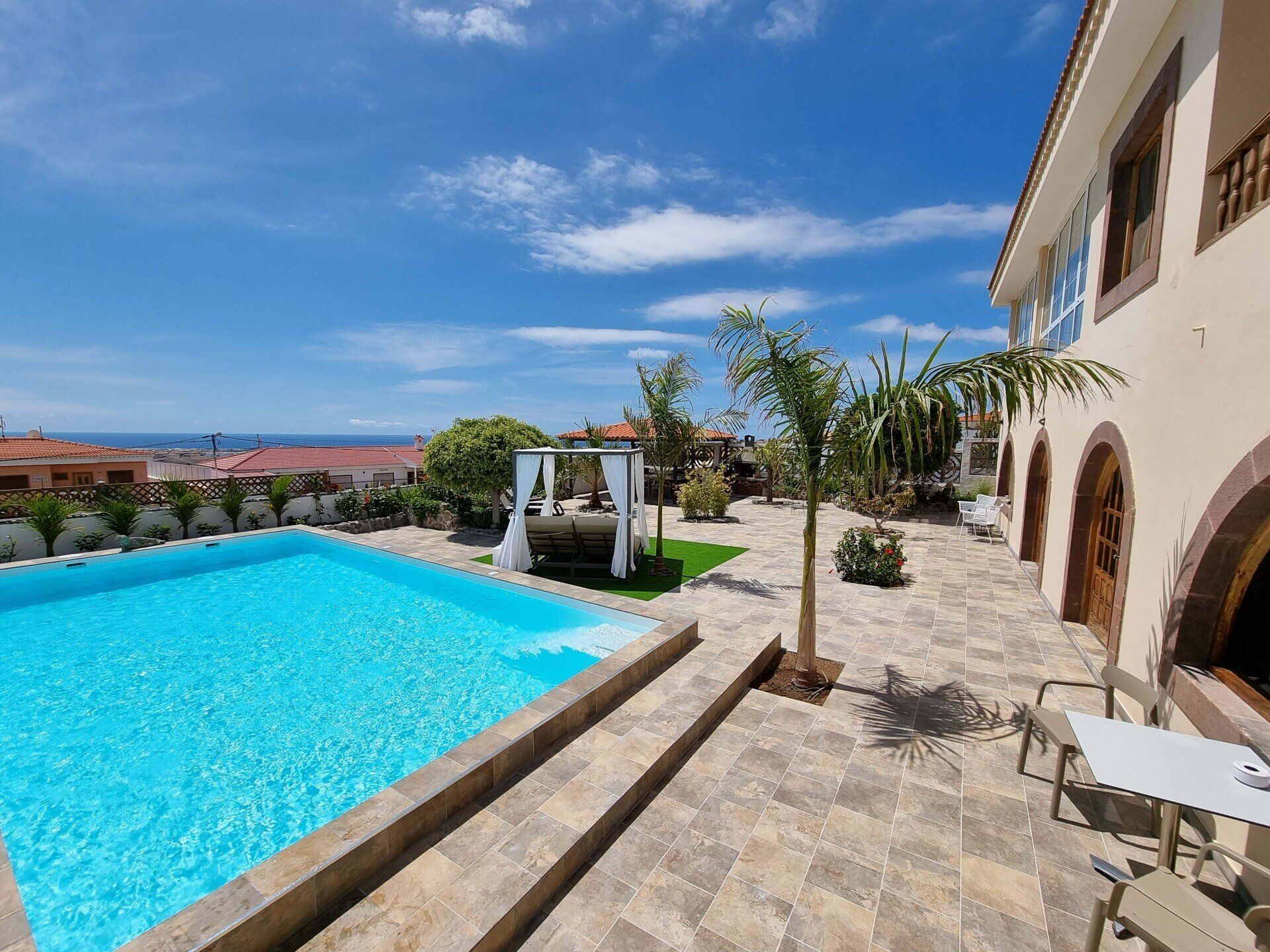 Im Hinterhof eines Hauses befindet sich ein großer Swimmingpool.