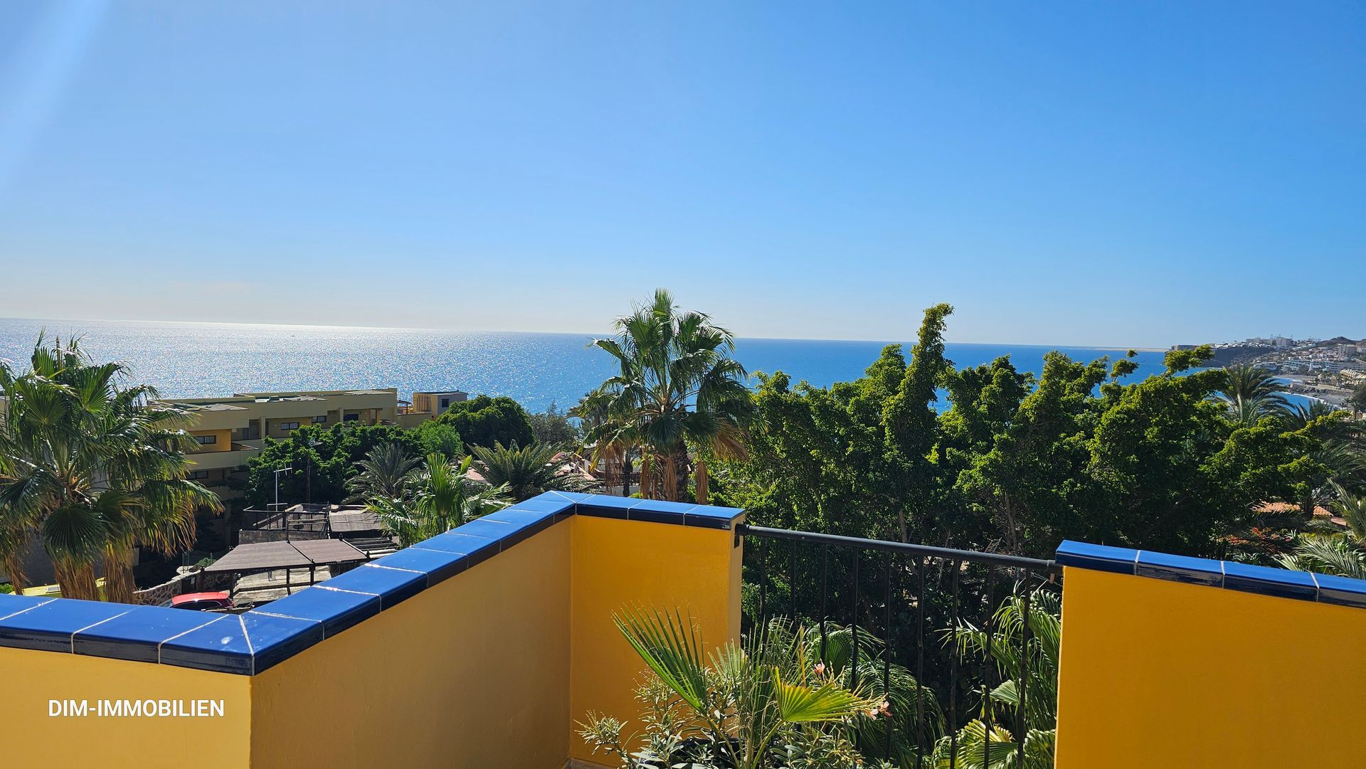 Ein Balkon mit Blick auf das Meer und die Bäume