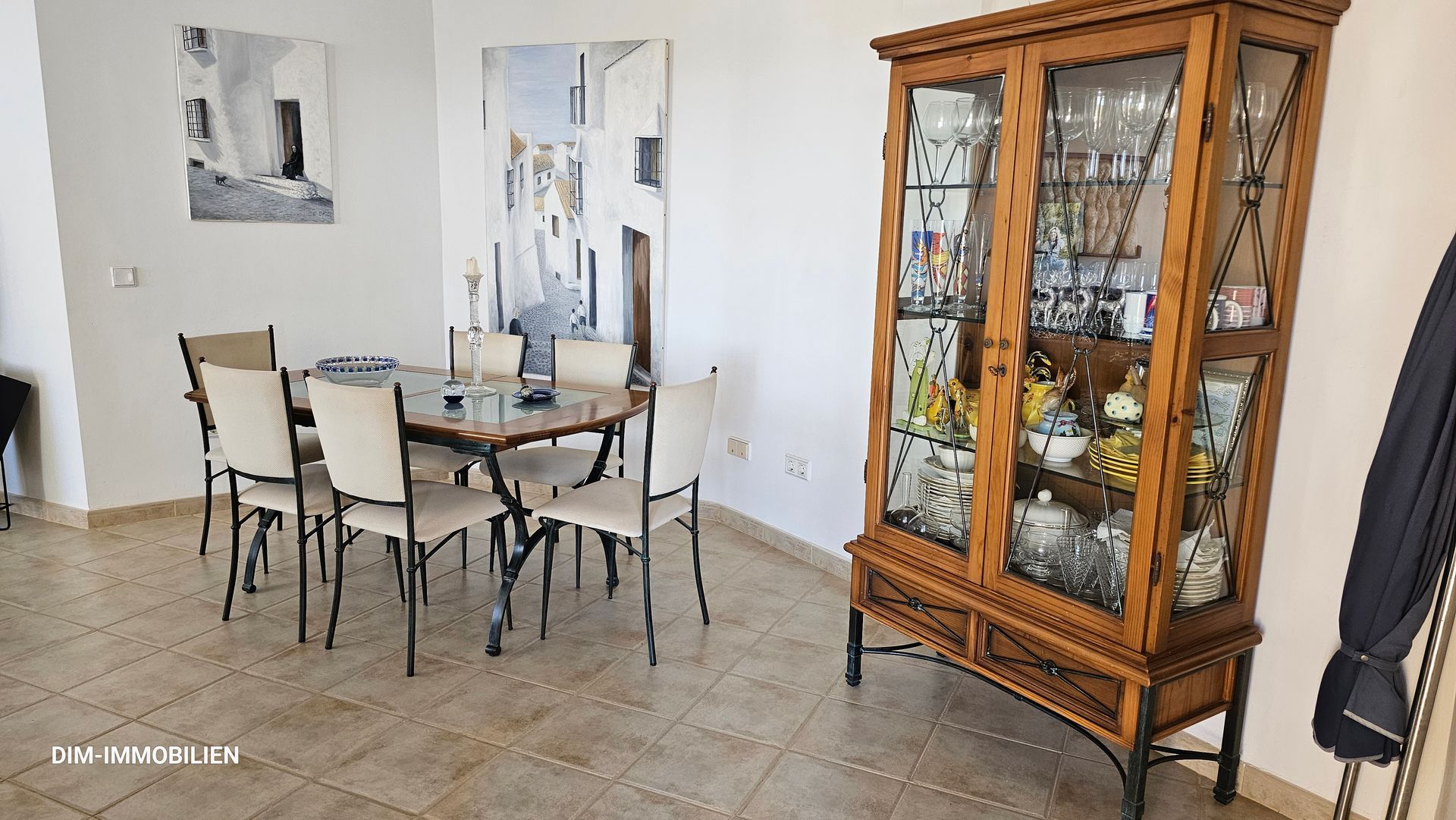 Ein Esszimmer mit Tisch und Stühlen und einer Glasvitrine