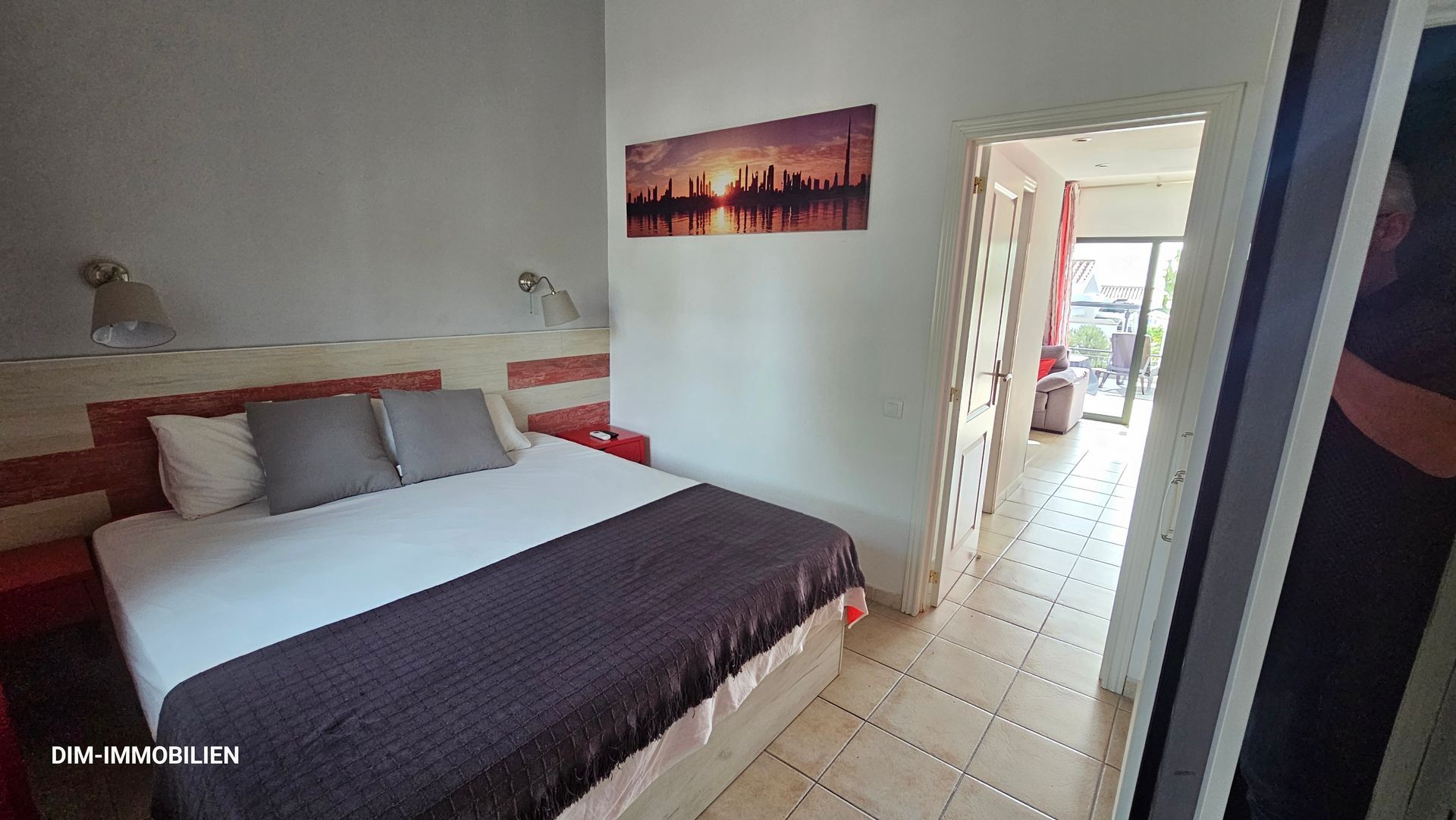 Ein Schlafzimmer mit einem großen Bett und einem Gemälde an der Wand.