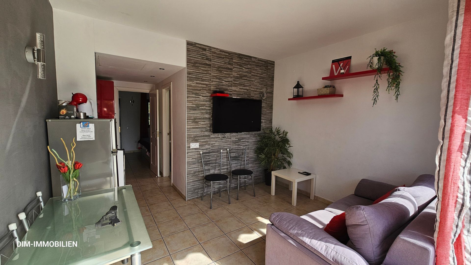 Ein Wohnzimmer mit Couch, Tisch und Fernseher.