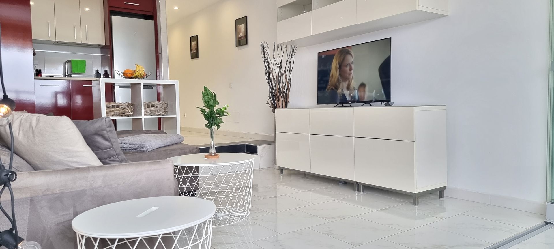 Ein Wohnzimmer mit Couch, Tisch und Fernseher.