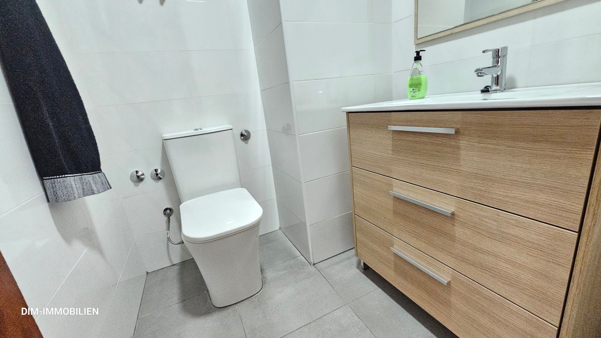Ein Badezimmer mit Toilette, Waschbecken und Kommode.