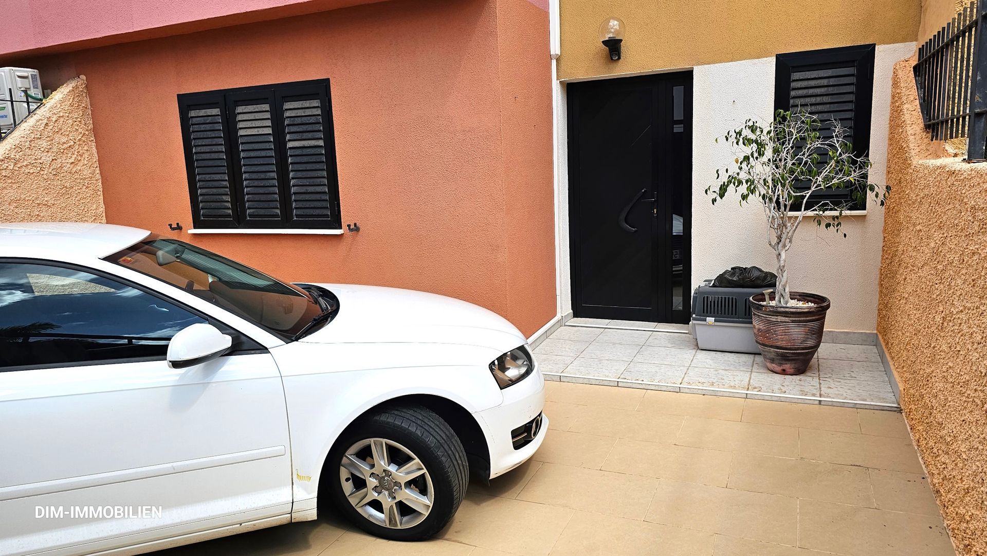 Ein weißes Auto steht vor einem Haus