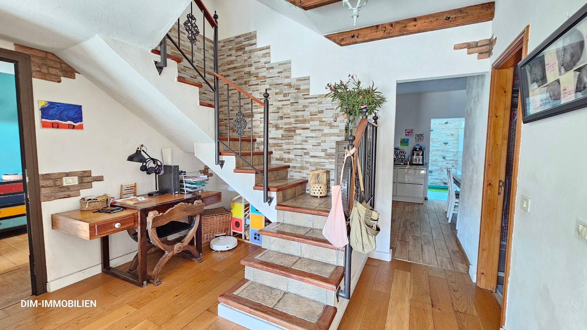 Ein Flur mit einer Treppe, die in den zweiten Stock eines Hauses führt.