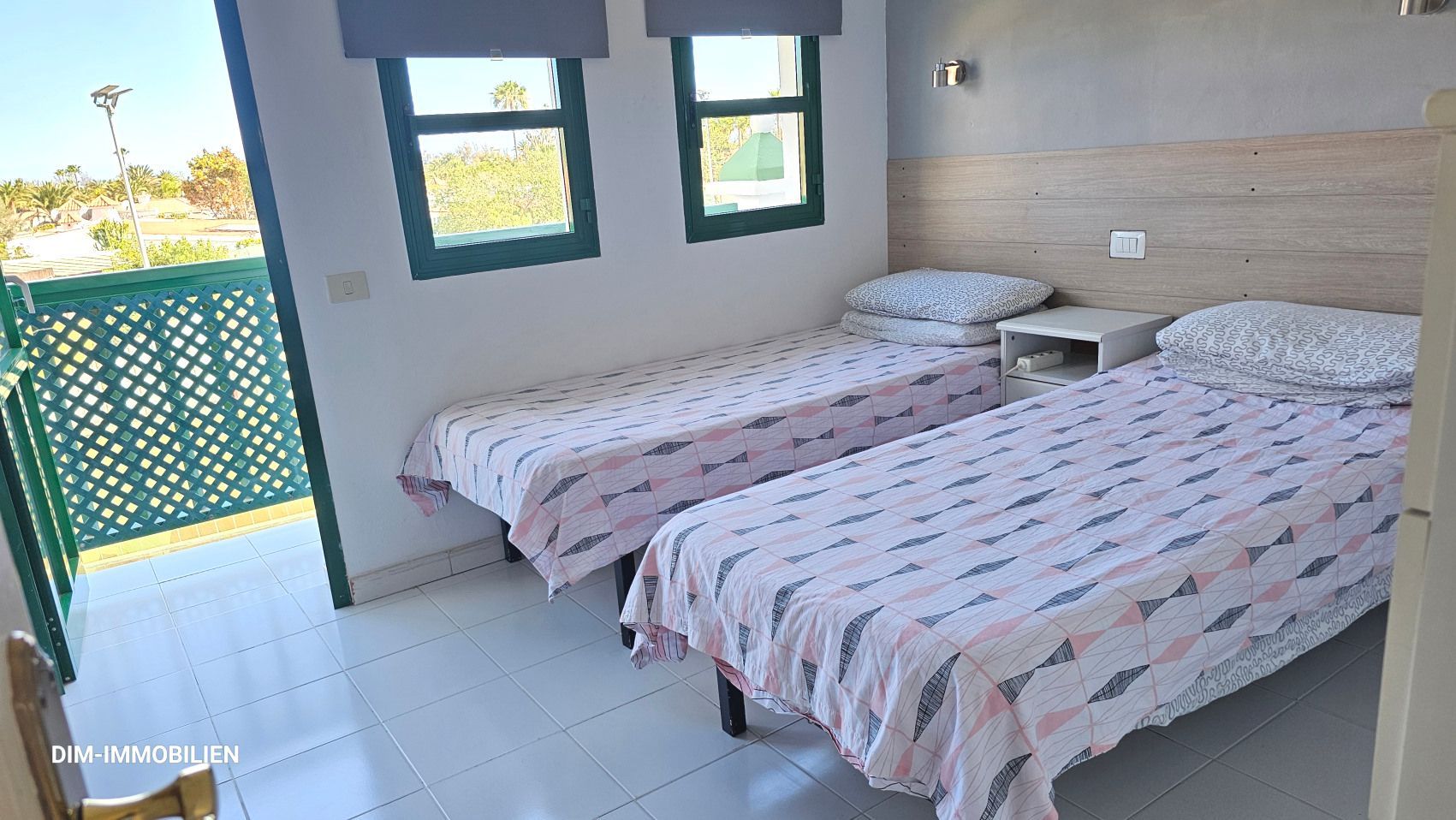 Ein Schlafzimmer mit zwei Einzelbetten und einem Balkon.