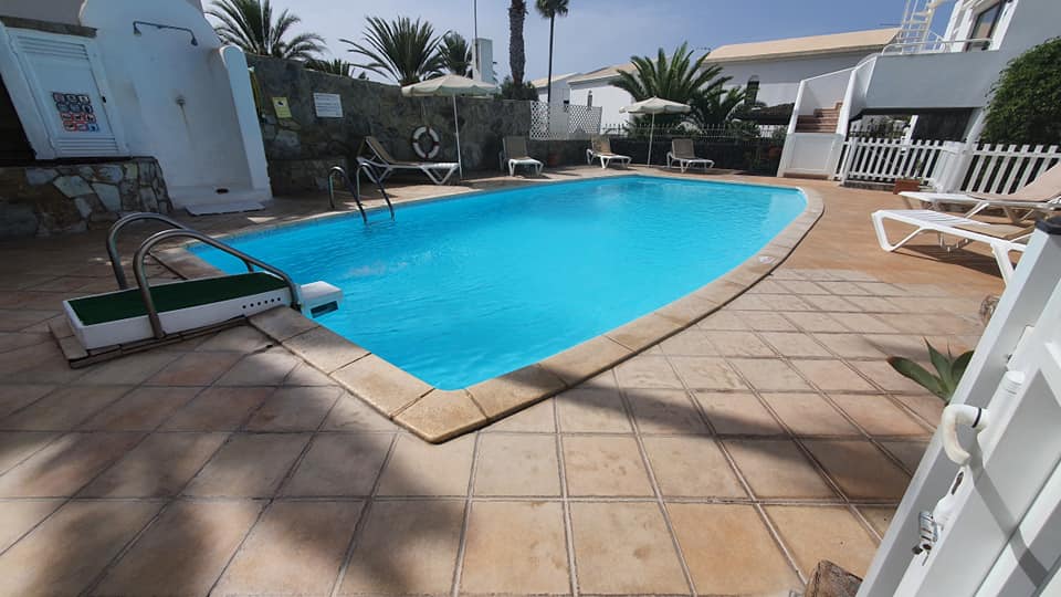 Ein großer Swimmingpool, umgeben von Stühlen und Sonnenschirmen