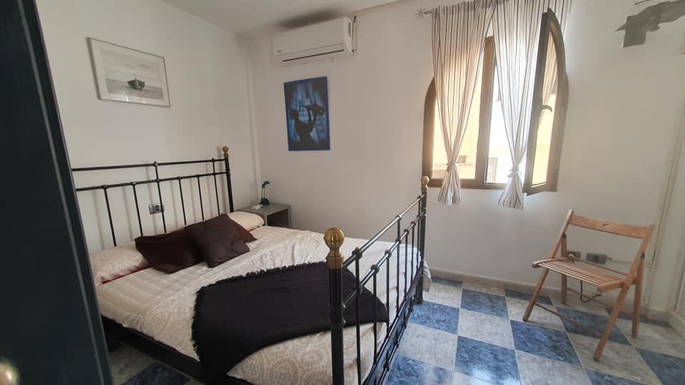 Ein Schlafzimmer mit Bett, Stuhl und Fenster.