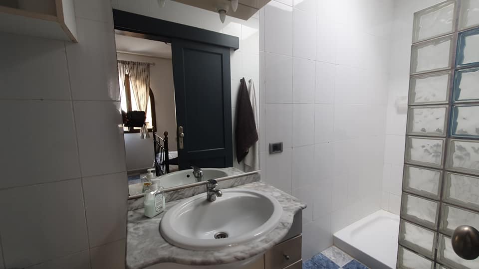 Ein Badezimmer mit Waschbecken, Spiegel und Dusche.