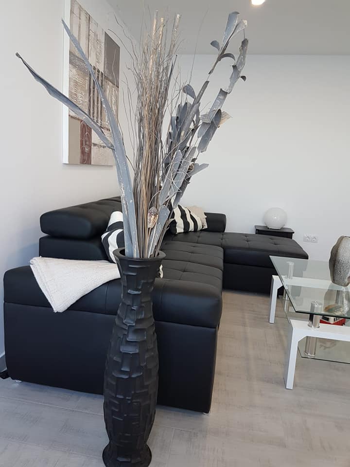 Ein Wohnzimmer mit einer schwarzen Couch und einem Couchtisch aus Glas