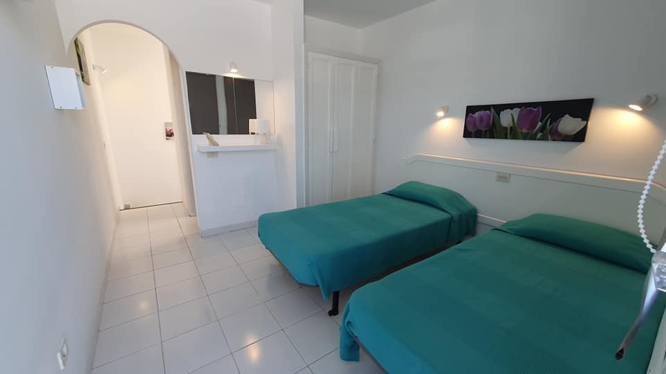 Ein Schlafzimmer mit zwei Betten und einem Gemälde an der Wand.