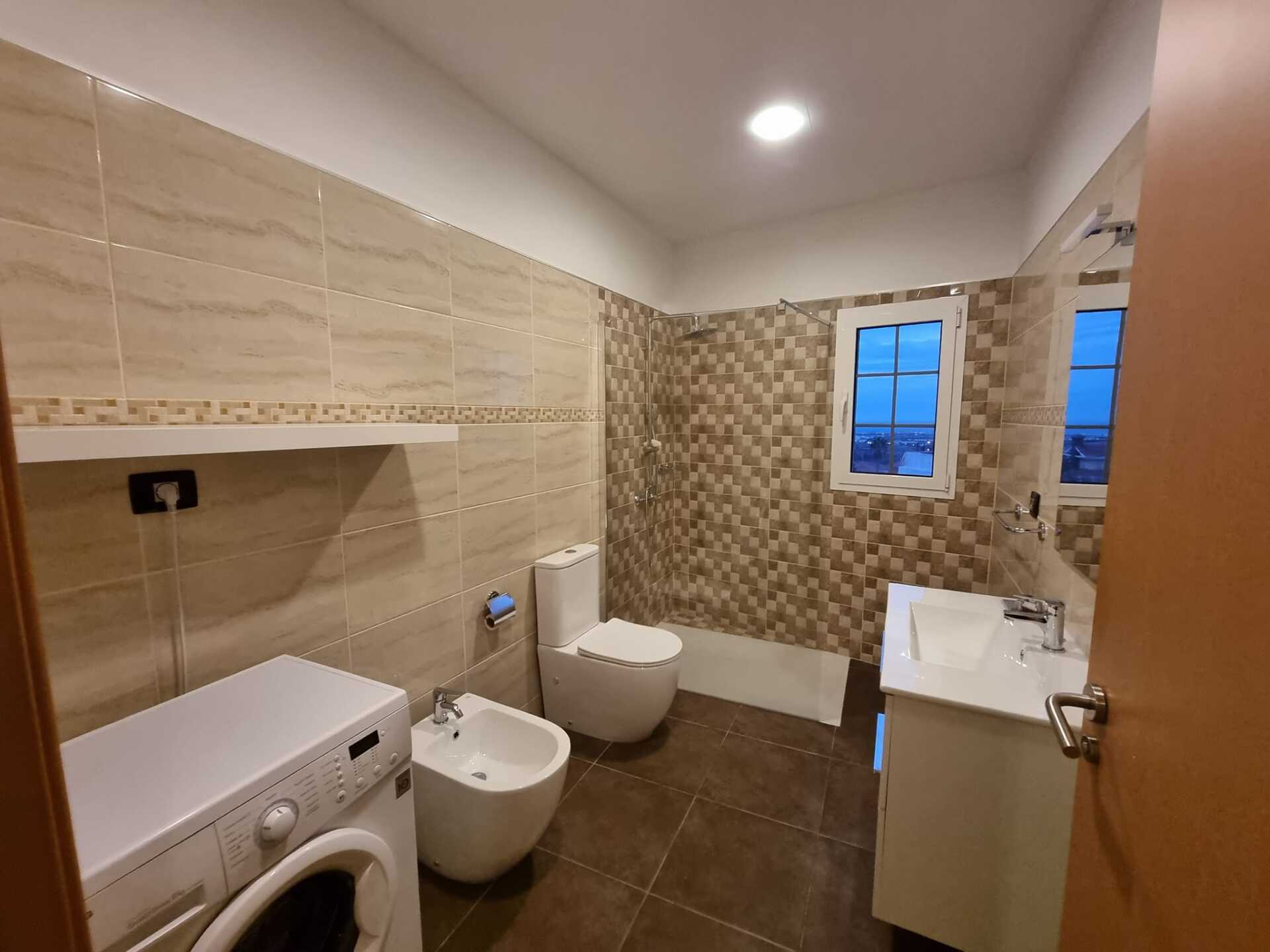 Ein Badezimmer mit Toilette, Bidet, Waschbecken und Waschmaschine.