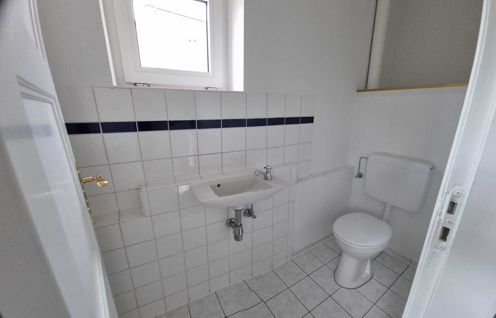 Ein Badezimmer mit Toilette, Waschbecken und Fenster