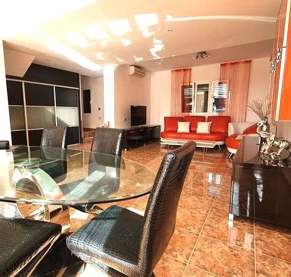 Ein Wohnzimmer mit Glastisch und Stühlen