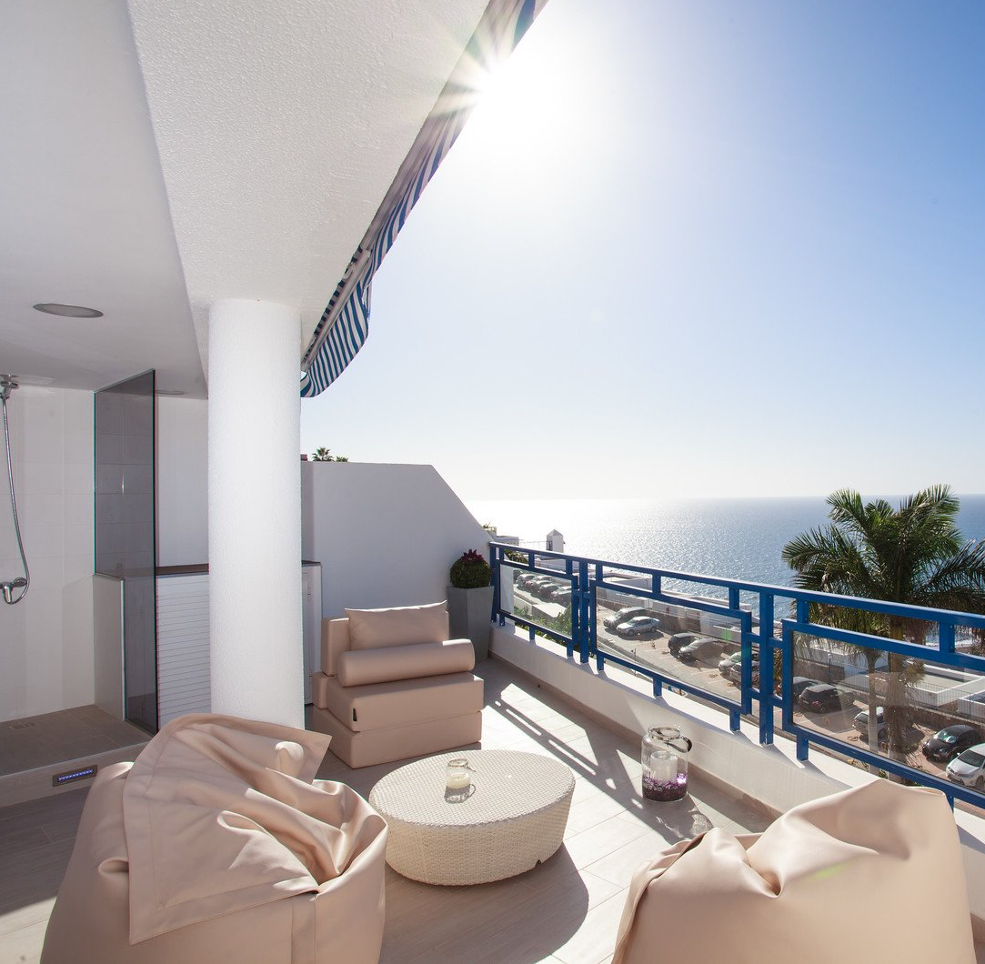 Ein Balkon mit Sitzsäcken und einem Tisch mit Blick auf das Meer