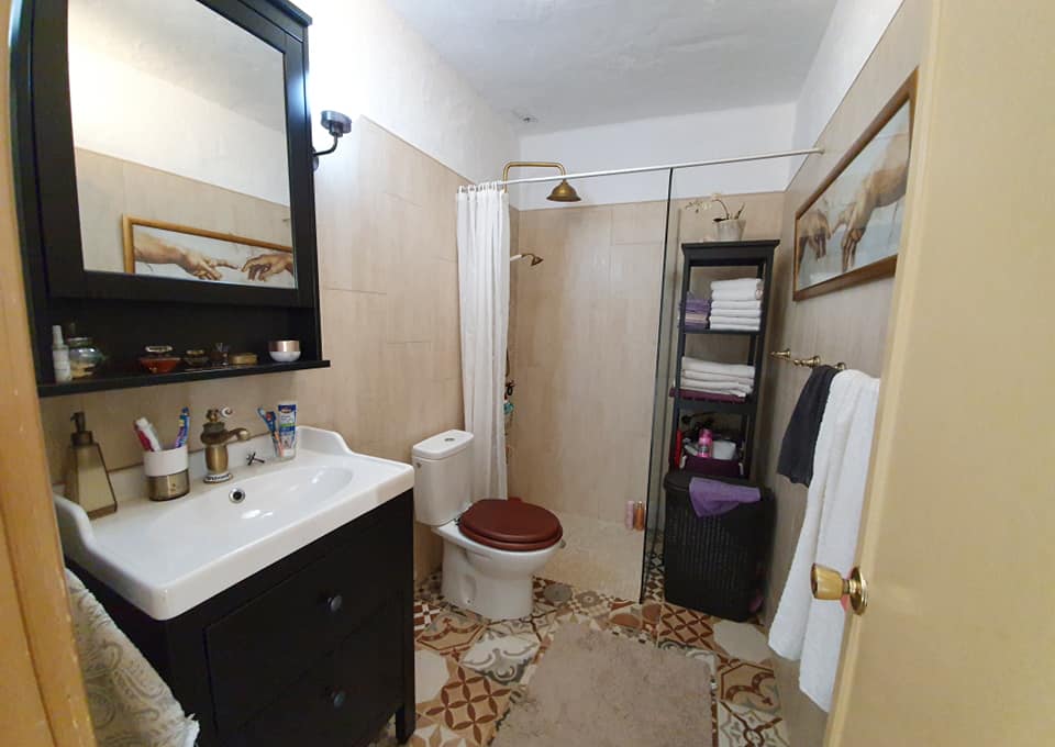 Ein Badezimmer mit Toilette, Waschbecken, Spiegel und Dusche.