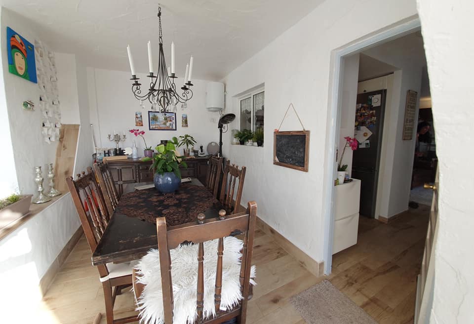 Ein Esszimmer mit Tisch, Stühlen und einem Kronleuchter.