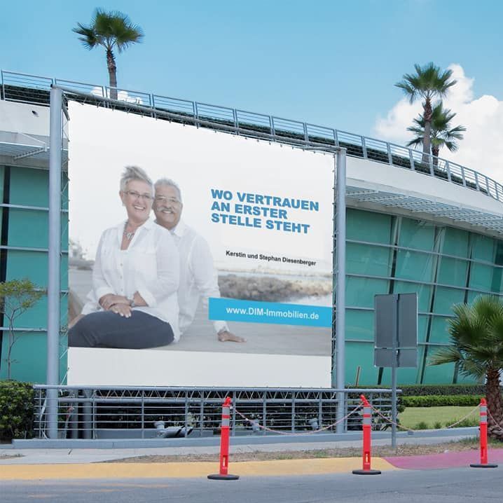 A large billboard on the side of a building says wo vertrauen an erster stelle steht