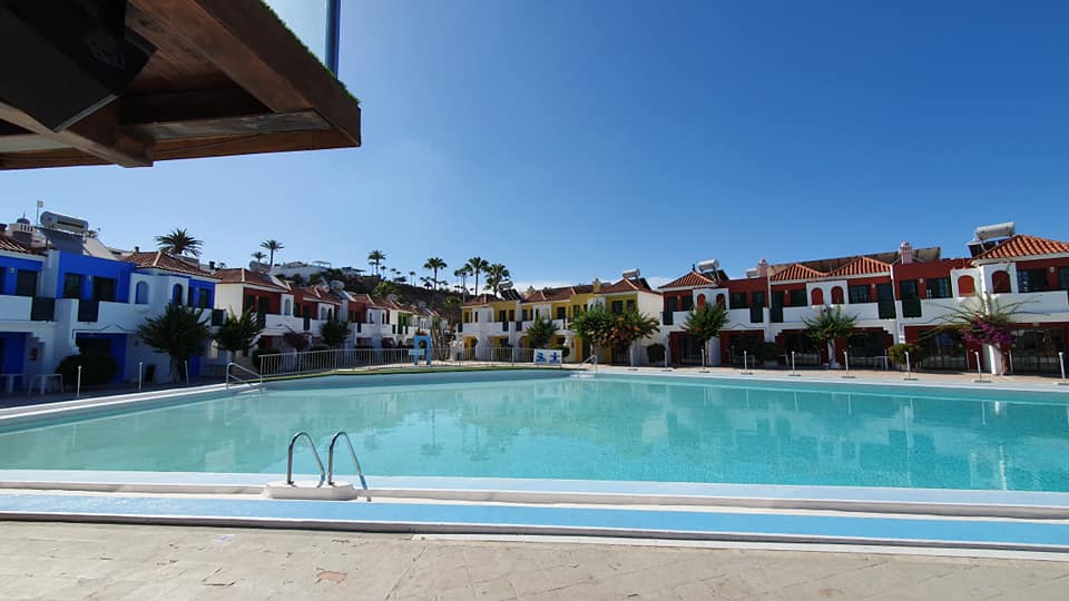 Ein großer Swimmingpool, umgeben von Häusern an einem sonnigen Tag
