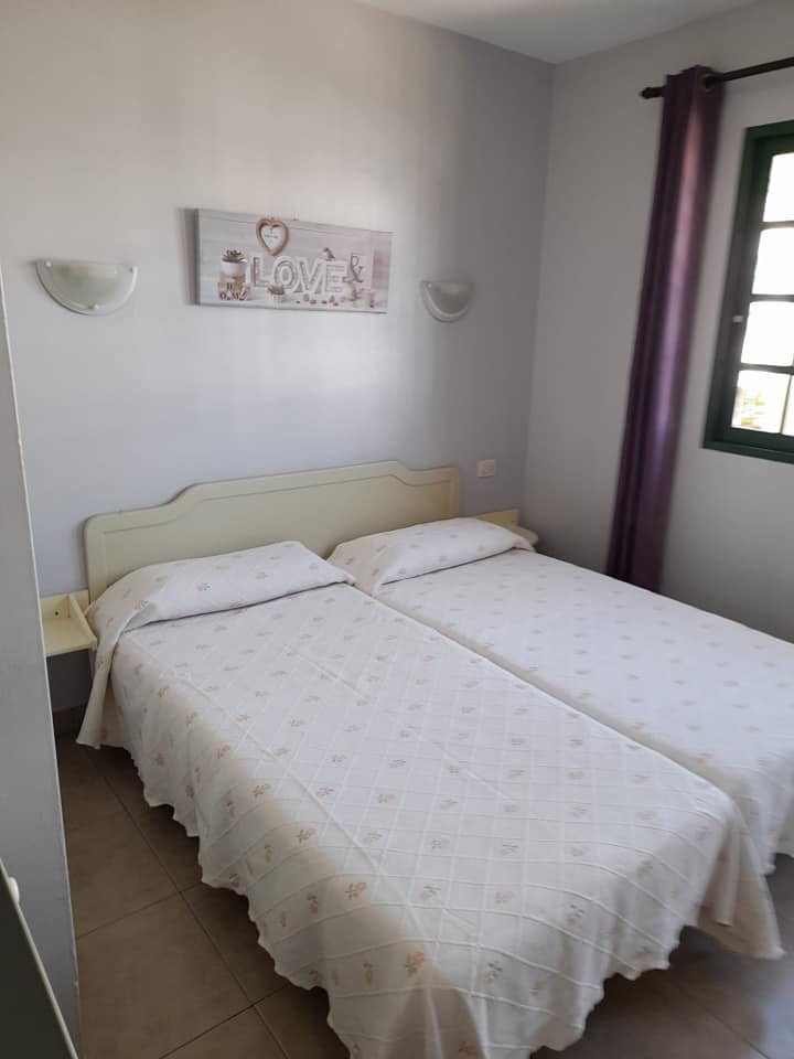 Ein Schlafzimmer mit zwei Betten und einem Gemälde an der Wand.