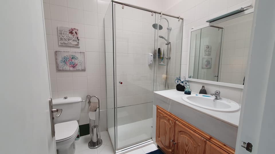 Ein Badezimmer mit Toilette, Waschbecken, Dusche und Spiegel.