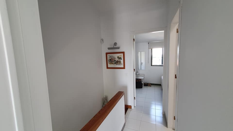 Ein Flur, der zu einem Badezimmer und einer Treppe in einem Haus führt.