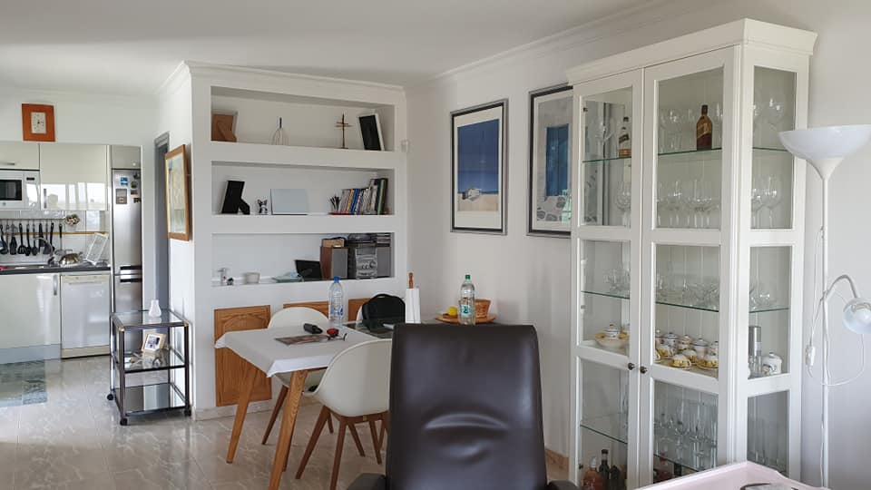 Ein Wohnzimmer mit Tisch und Stühlen und einer Glasvitrine.