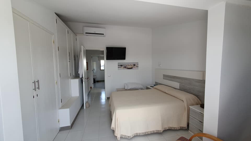 Ein Schlafzimmer mit großem Bett und Flachbildfernseher