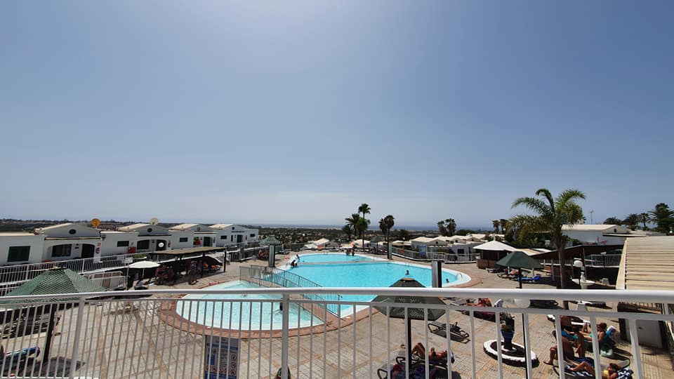 Ein Blick von einem Balkon auf einen großen Swimmingpool.