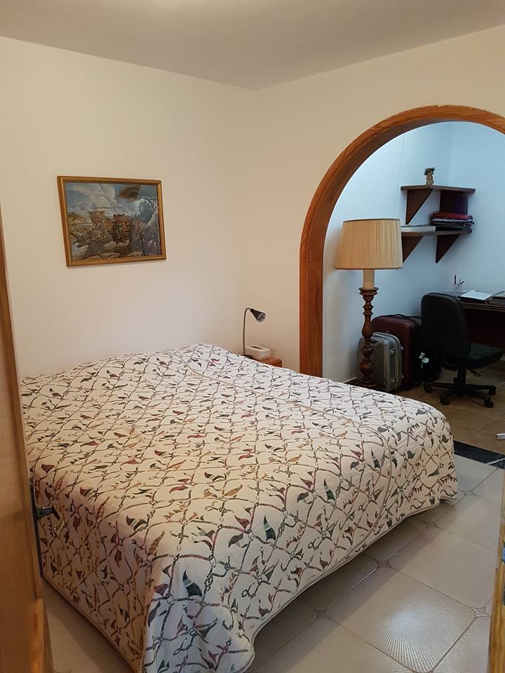 Ein Schlafzimmer mit einem großen Bett und einer Lampe