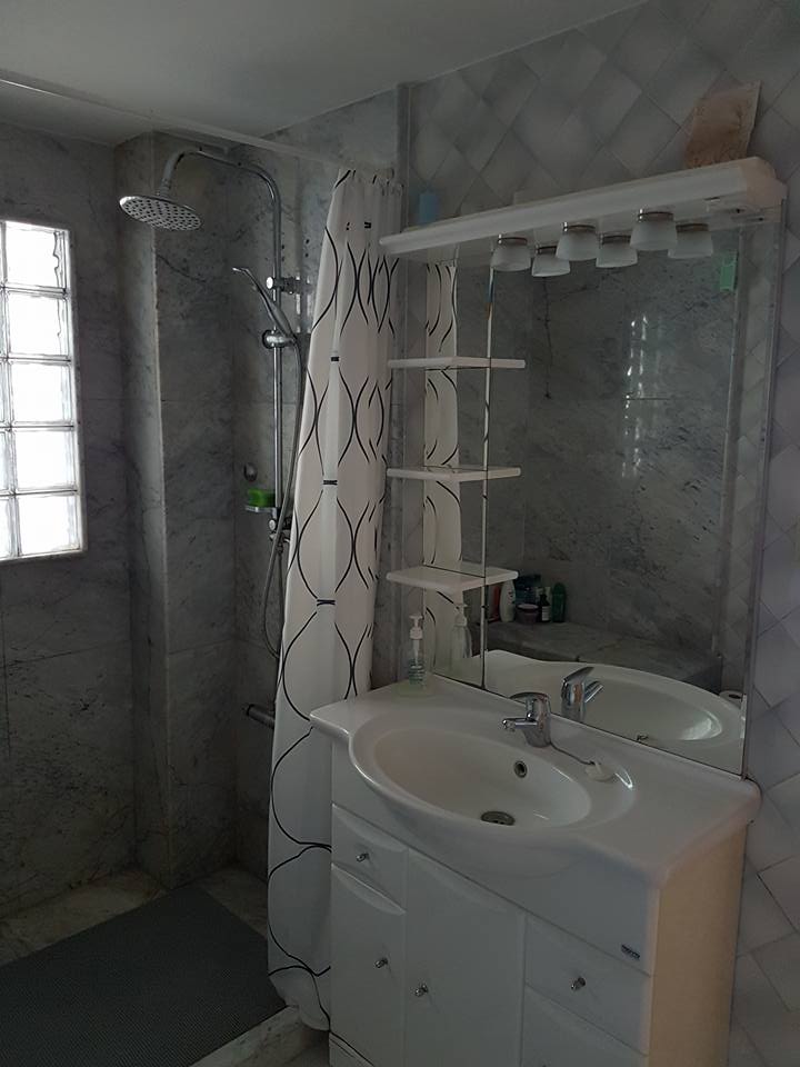Ein Badezimmer mit Waschbecken, Spiegel und Dusche.