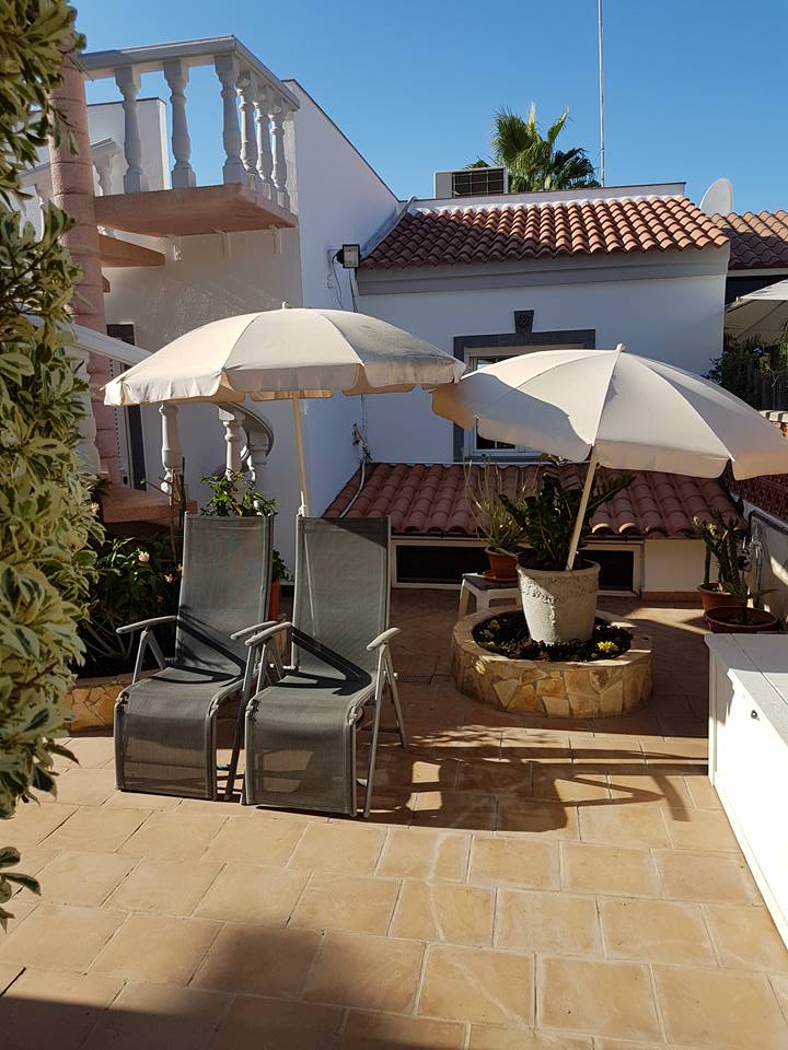 Eine Terrasse mit Stühlen und Sonnenschirmen an einem sonnigen Tag