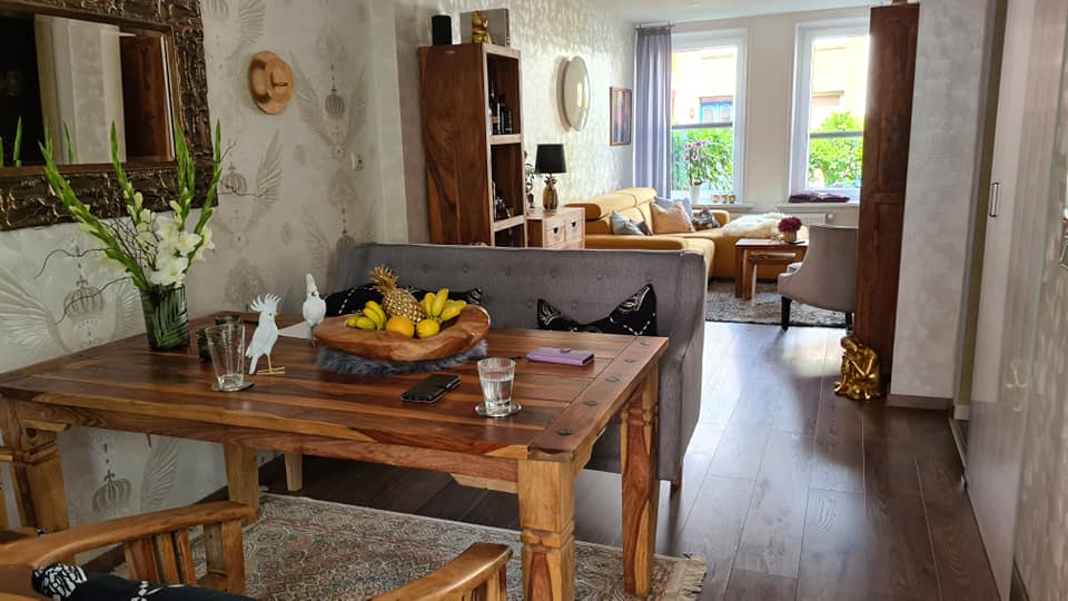 Ein Wohnzimmer mit einem Holztisch und Stühlen und einer Couch.