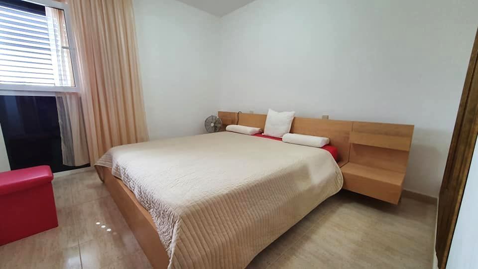 Ein Schlafzimmer mit einem großen Bett und einer roten Ottomane