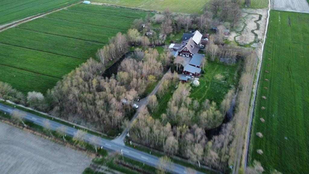 Eine Luftaufnahme eines Hauses, umgeben von Bäumen und Feldern.