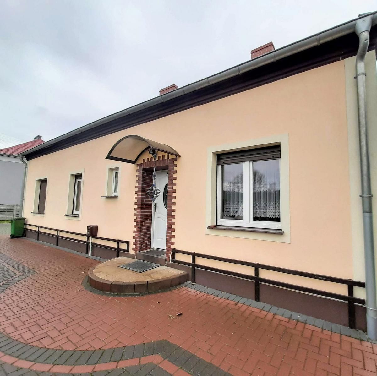 Ein Haus mit einem gemauerten Gehweg, der zur Haustür führt
