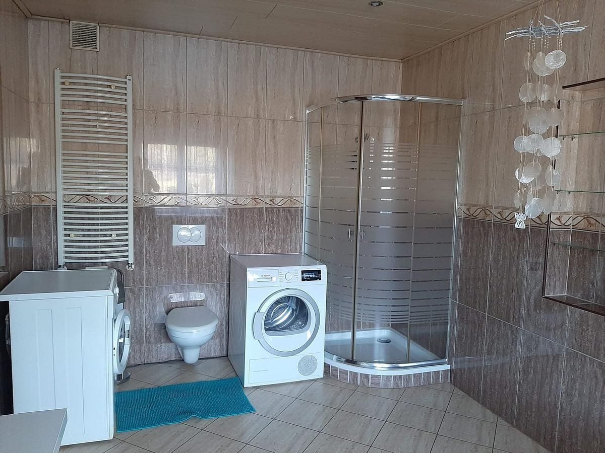 Ein Badezimmer mit Waschmaschine, Toilette und Dusche.