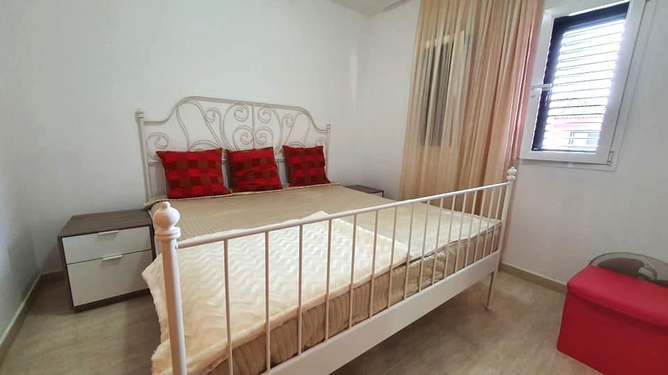 Ein Schlafzimmer mit einem Bett, Nachttischen und einem Fenster.