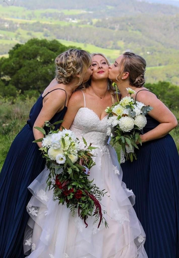 The Bride and Her Bridesmaids Are Kissing the Bride on the Cheek — Xquisite Styles in Mount Warrigal, NSW